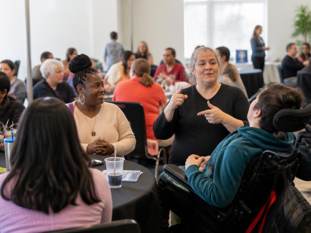 Adults, families, and caregivers of diverse ages and abilities participating in an inclusive community workshop and resource fair
